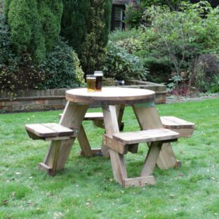 A four person circular picnic table on a pub lawn