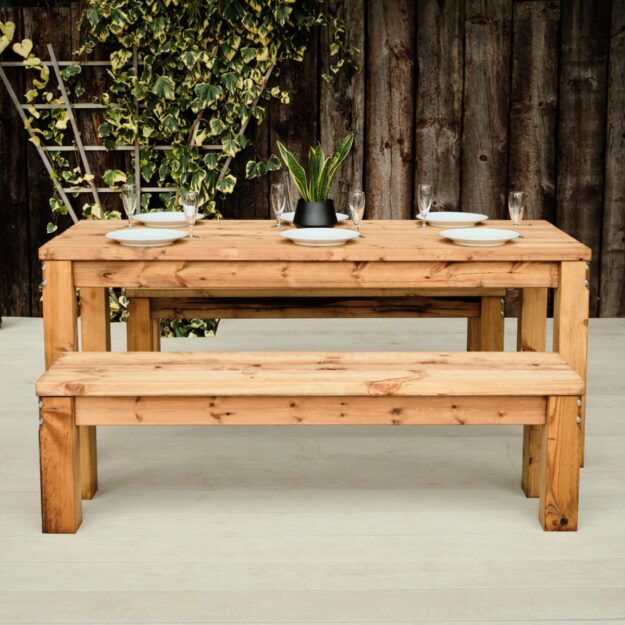 A chunky wooden rectangular outdoor dining table with matching bench seats each side seating 6 people