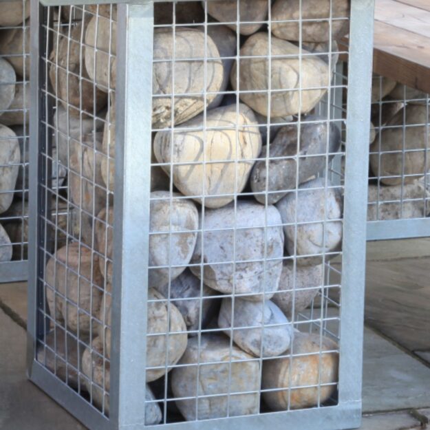 A close up of large round stones in a gabion metal cage