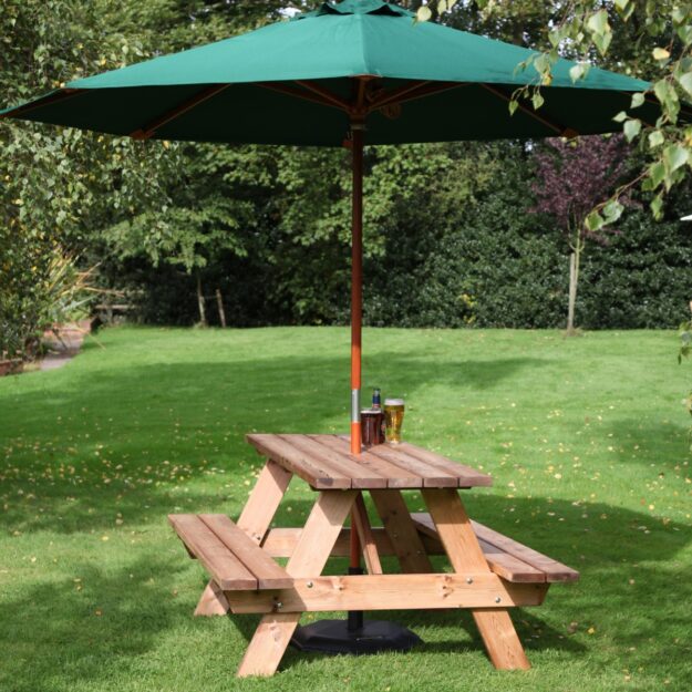 A 1.5 metre long wooden a frame picnic table with a green parasol on a pub lawn
