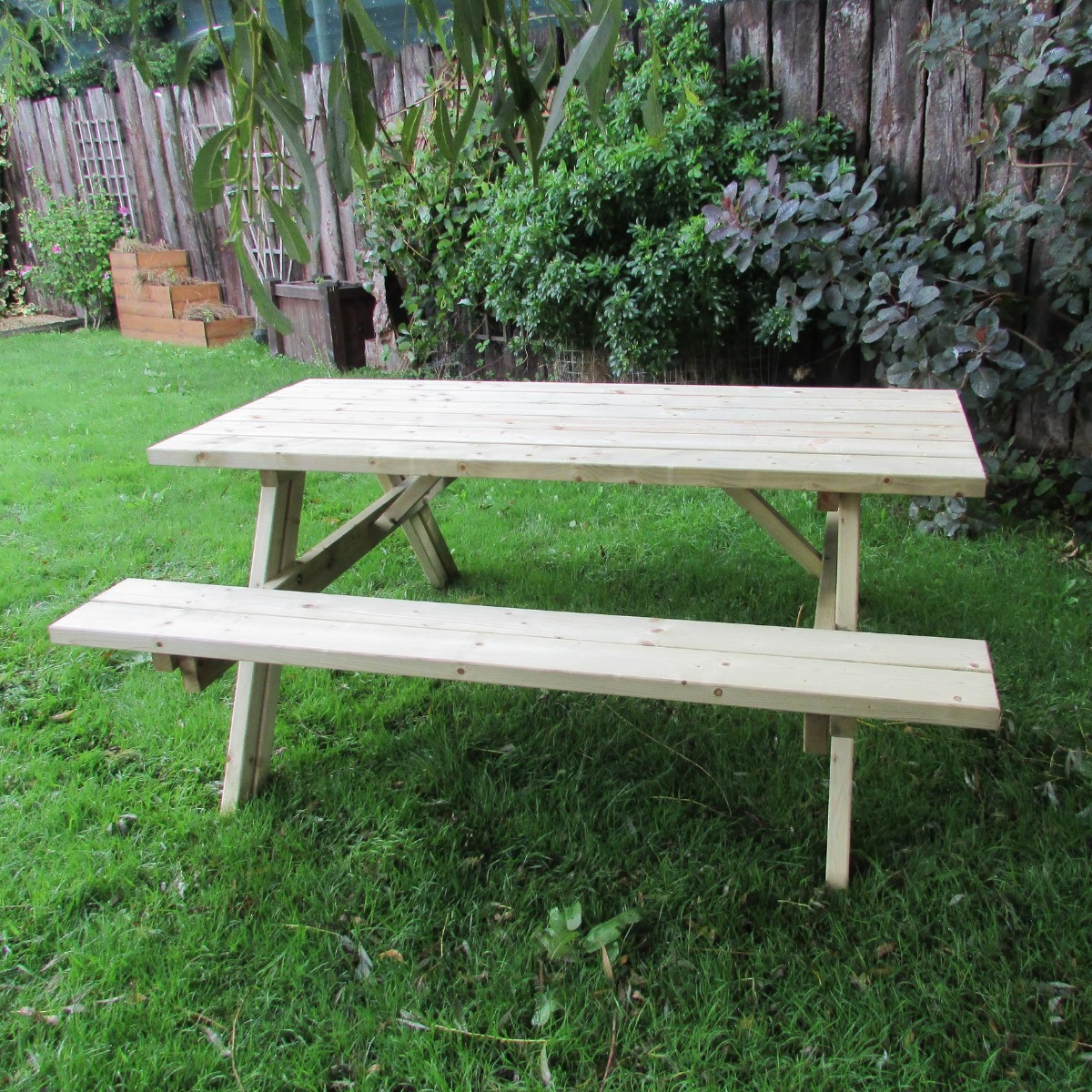 A wooden a frame picnic table on a lawn