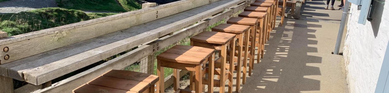 Solidly built wooden bar stools located at the outdoor cafe, Tintagel Castle