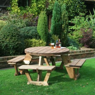 A circular wooden picnic table seating 8 people located on a lawn