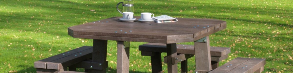 A large well made square 8 seater picnic table made from recycled plastic in a garden setting