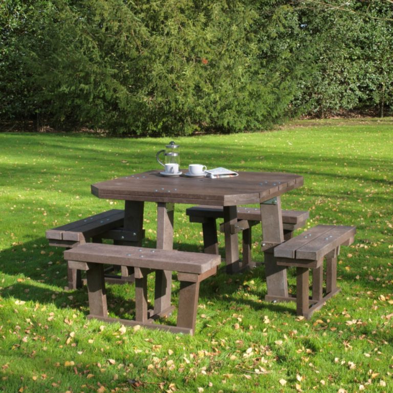 A large well made square 8 seater picnic table made from recycled plastic in a garden setting