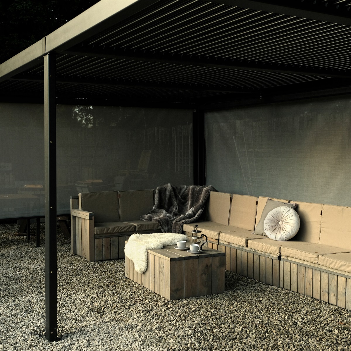 A luxury rectangular grey metal gazebo with an L shaped wooden sofa and cushions underneath