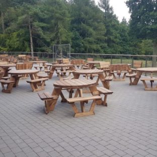 A Patio over looking the Chilterns Forest with a range of wooden 6 and 8 seater round picnic tables on it