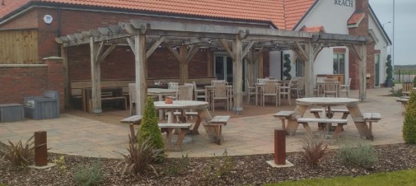 The Kings Reach pub garden with circular 8 seater wooden picnic tables and 8 square teak table and dining chair sets