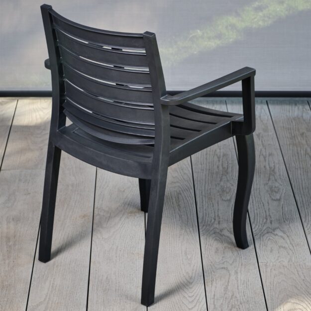 A back view of a robust dark grey polypropylene outdoor stackable armchair