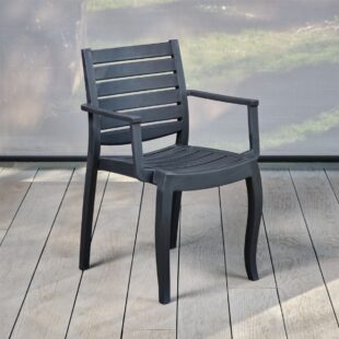 A dark grey robust polypropylene outdoor dining armchair on a grey outdoor deck