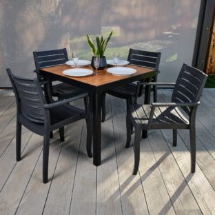 A square outdoor dining table with aluminium legs and laminate wood effect table top and 4 dark grey plastic chairs set for dinner on an outdoor grey deck