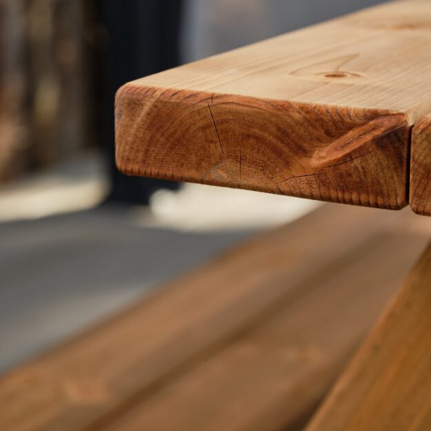 Showing a thick wooden plank table top of an a frame picnic table