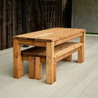 A commercial outdoor rectangular wooden dining table and bench set showing the benches stored under the table