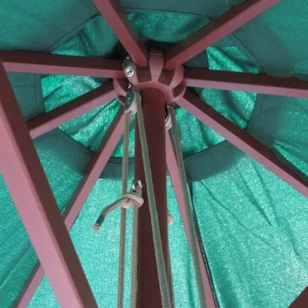 The underside of a green commercial parasol showing the wooden parasol spurs and pulley system
